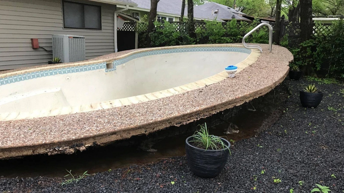 An image of a fibreglass pool that has popped out of the ground due to groundwater and saturated soil