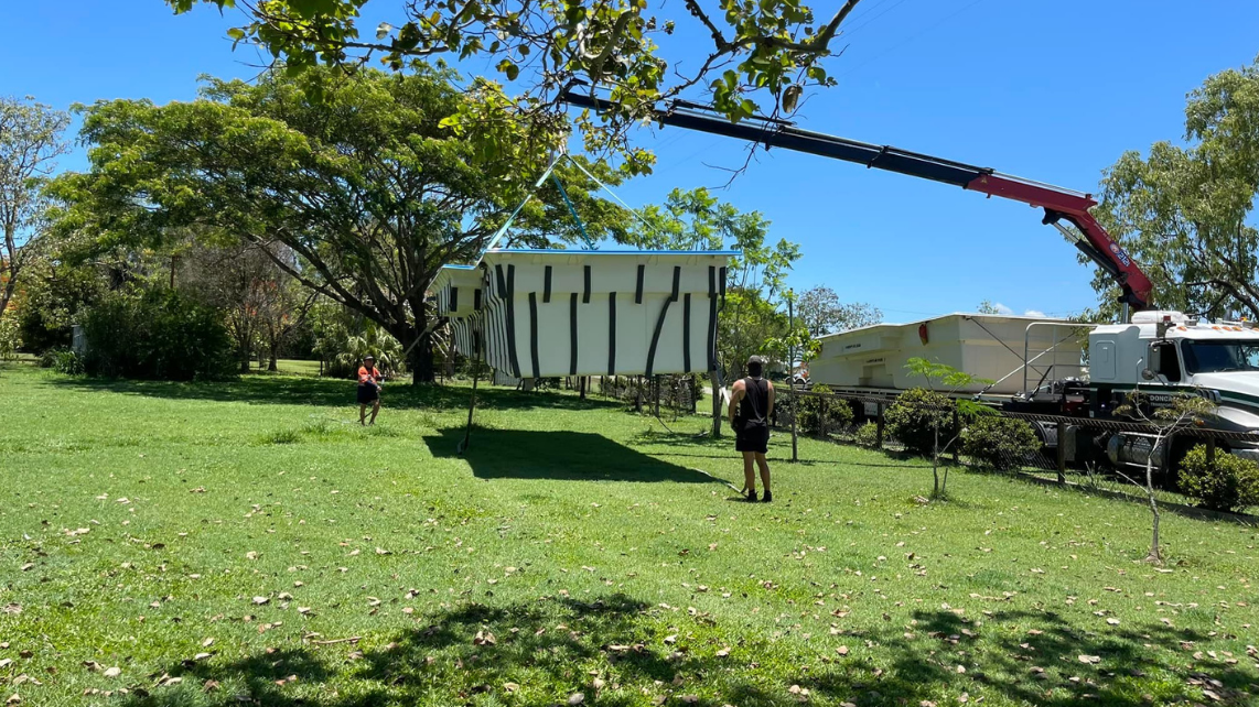 A fibreglass pool shell being lifted by a mobile crane, being conducted and taken by Pool Professionals Mackay
