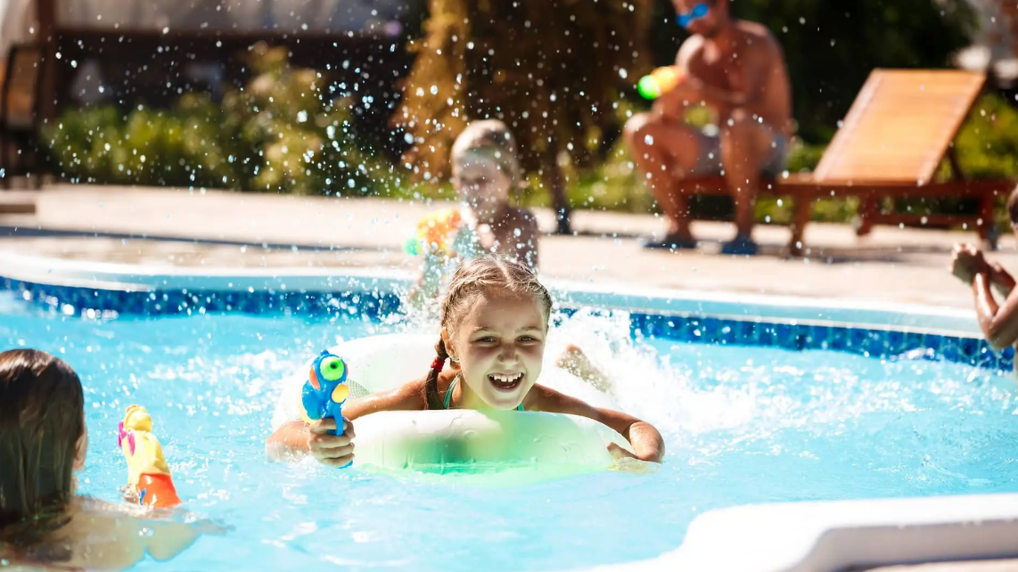An image of a girl playing on the pool with her family